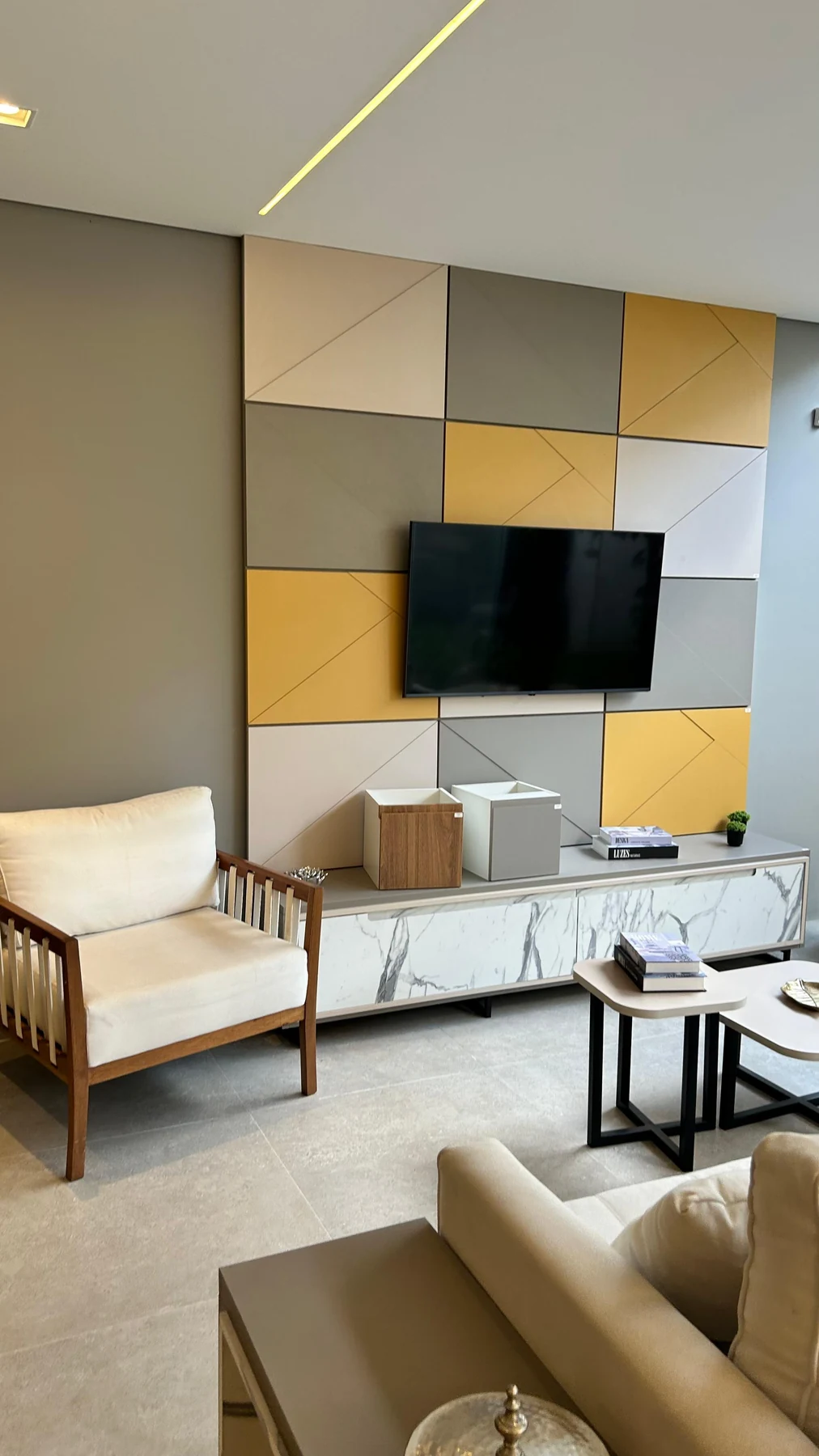 Sala real com painel de TV em tons neutros e mobiliário sob medida